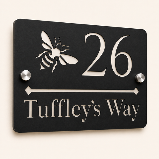 Close-up angled view of personalised black rectangular acrylic house sign with mirror silver bee design and lettering