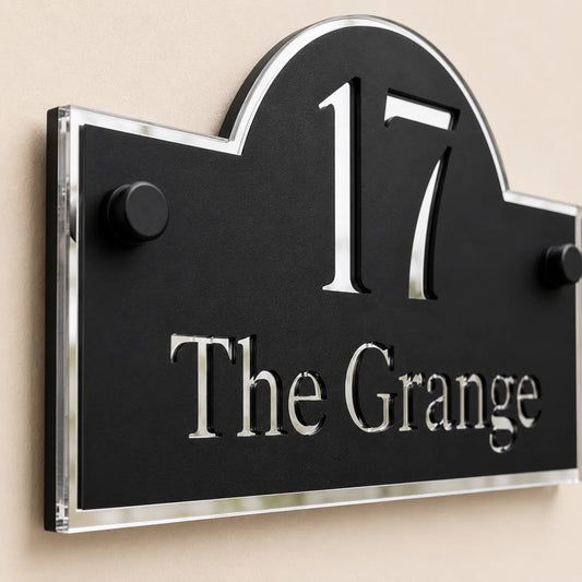 Close-up angled view of personalised black & silver arch acrylic house sign with mirror silver number and lettering
