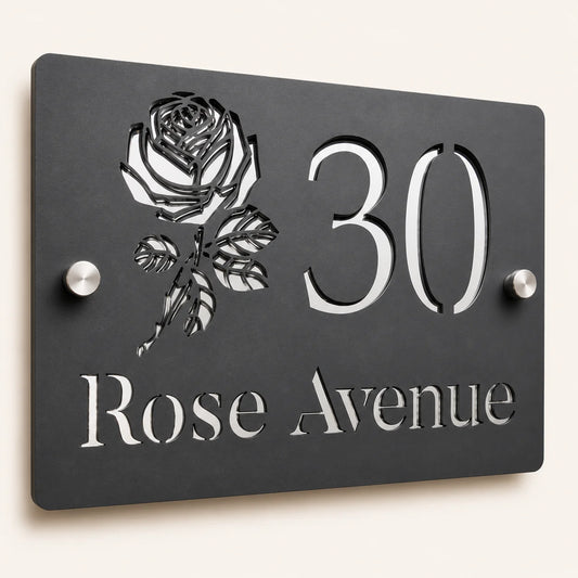 Close-up angled view of personalised mineral grey rectangular acrylic house sign with mirror silver rose design and lettering