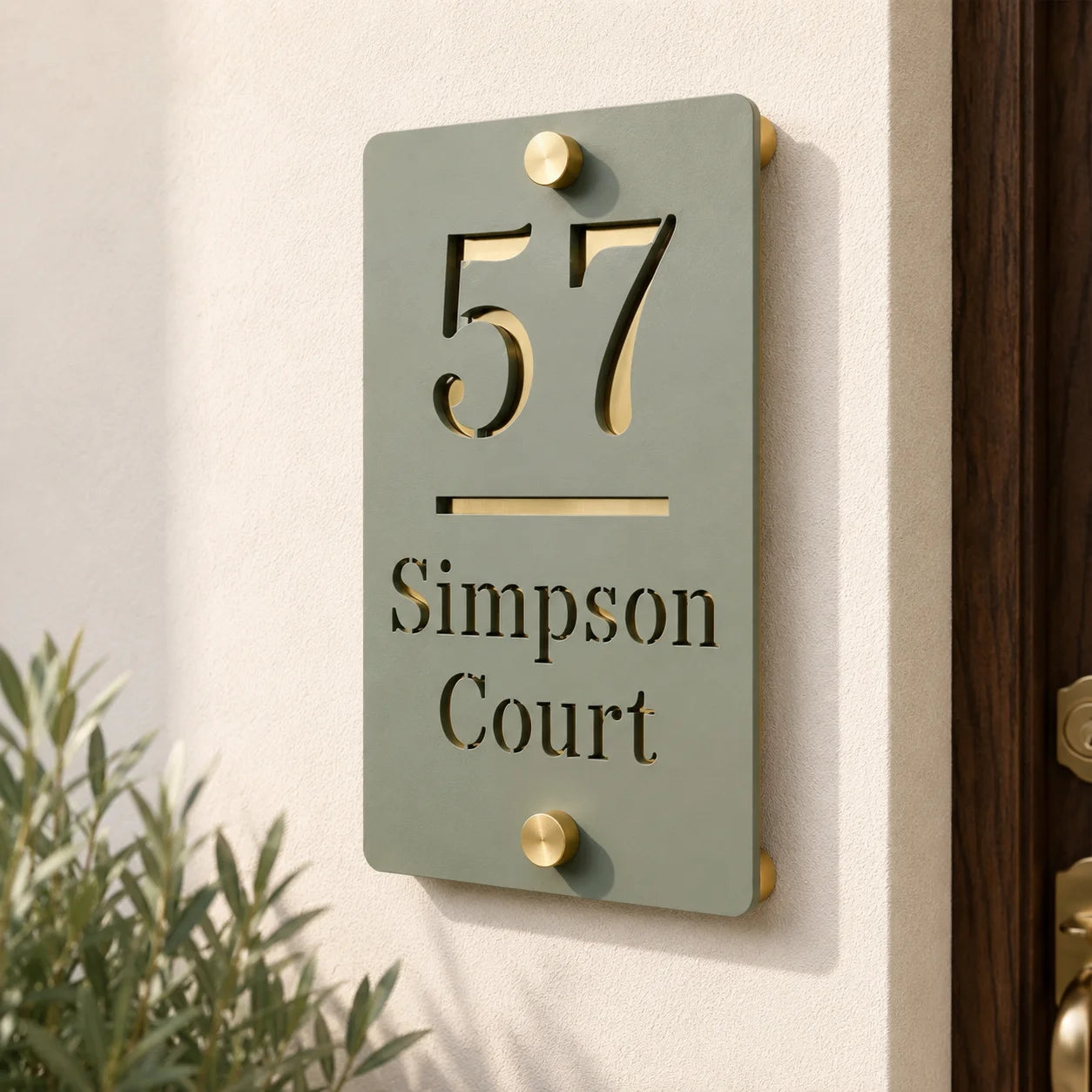 Close-up of personalised sage green and mirror gold acrylic house sign mounted beside a front door