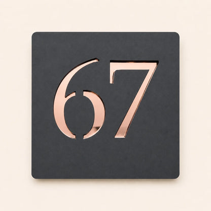 Personalised anthracite grey square acrylic house sign featuring raised rose gold mirror house number 67 with a modern minimalist design.