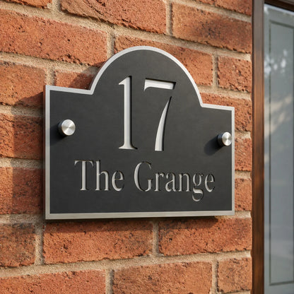 Close-up of personalised black and mirror silver acrylic arch house sign mounted on an exterior brick wall