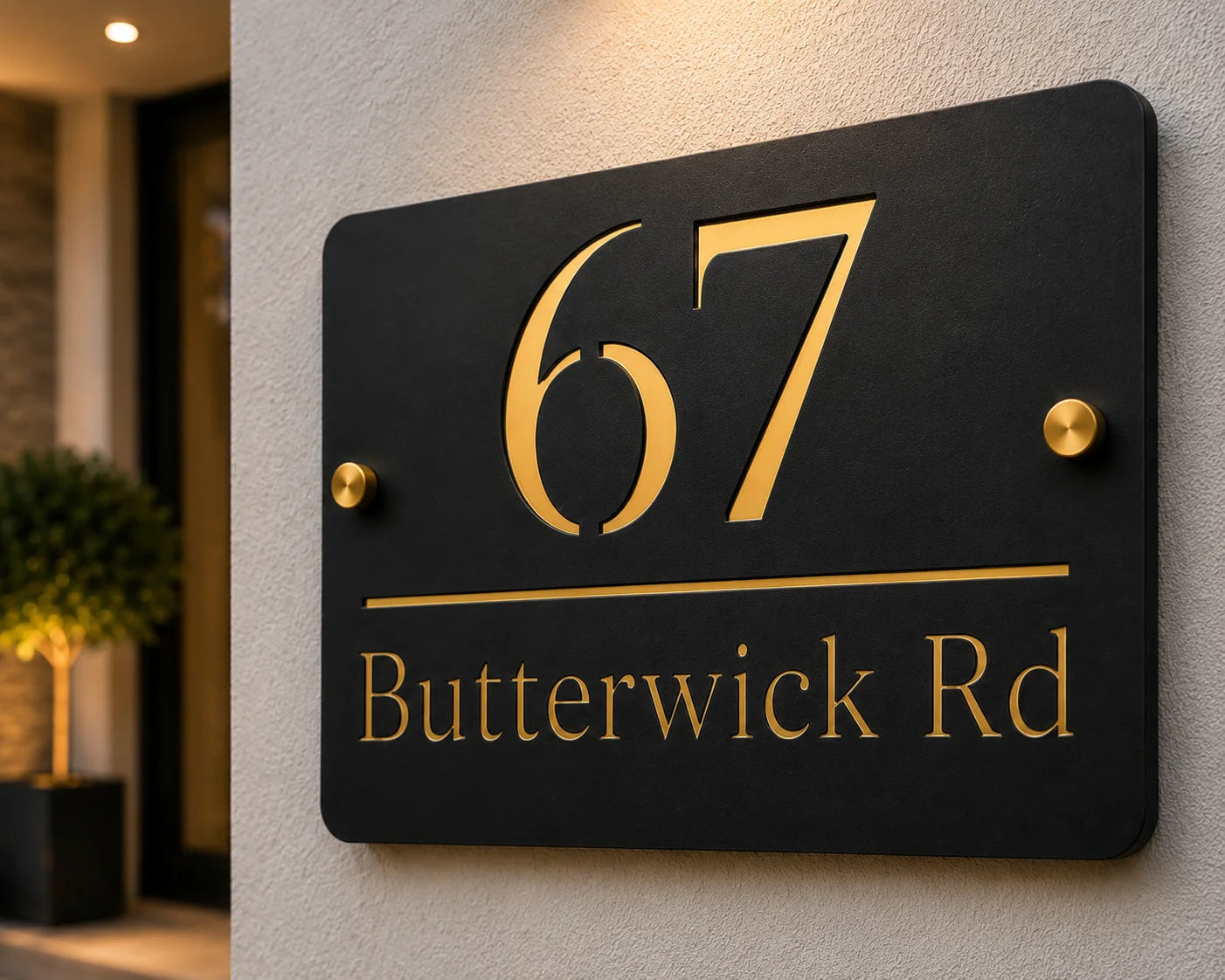 Close-up of personalised black & gold rectangular acrylic house sign with mirror gold detailing mounted beside a front door