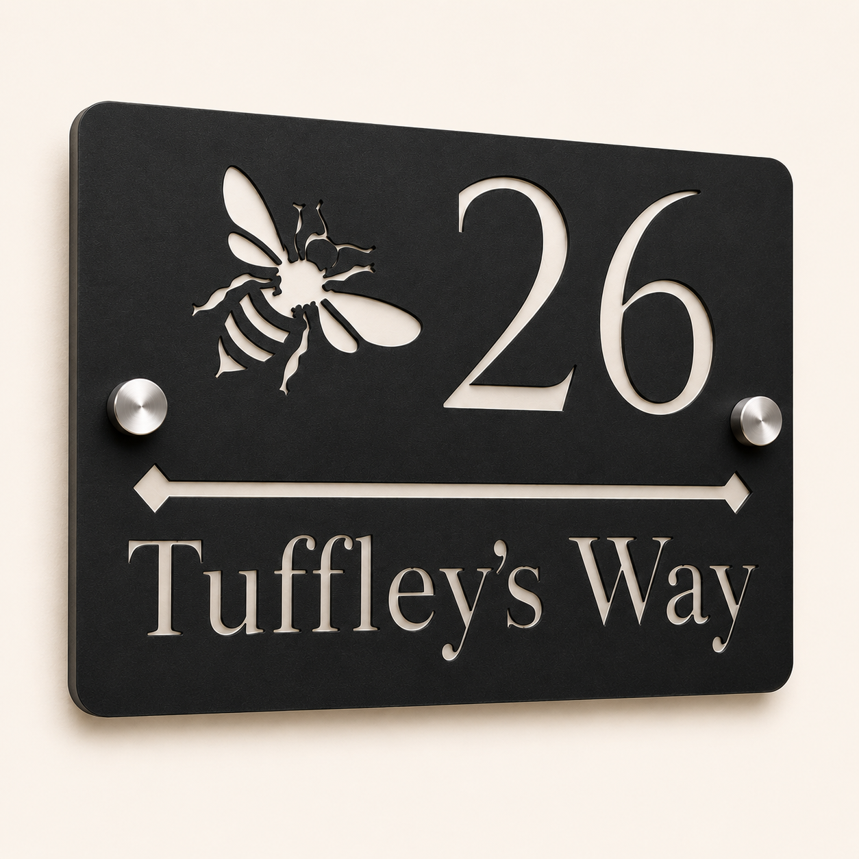 Close-up angled view of personalised black rectangular acrylic house sign with mirror silver bee design and lettering