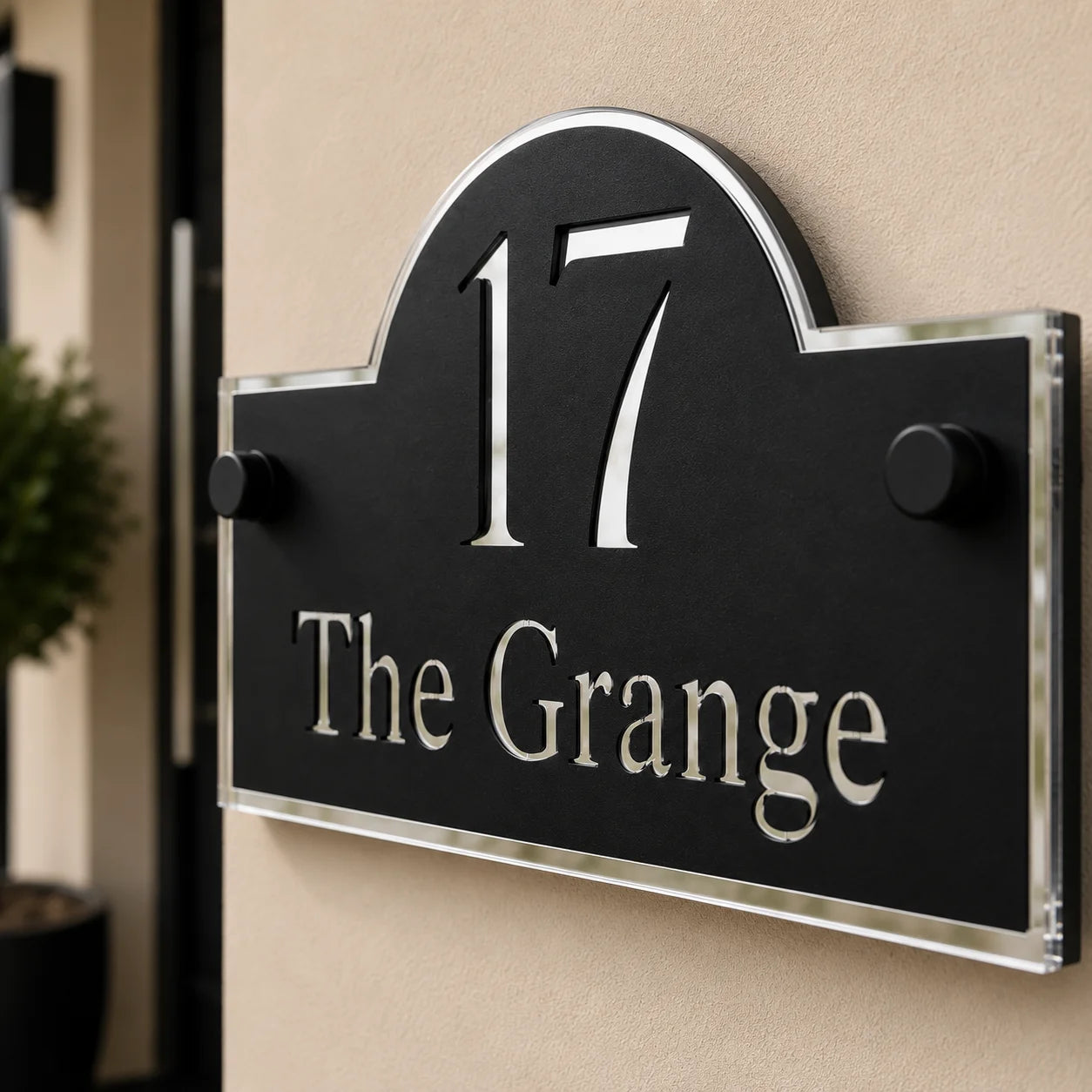 Close-up of personalised black & silver arch acrylic house sign with mirror silver detailing mounted beside a front door