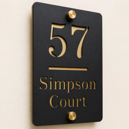 Close-up angled view of personalised black vertical acrylic house sign with mirror gold number and lettering