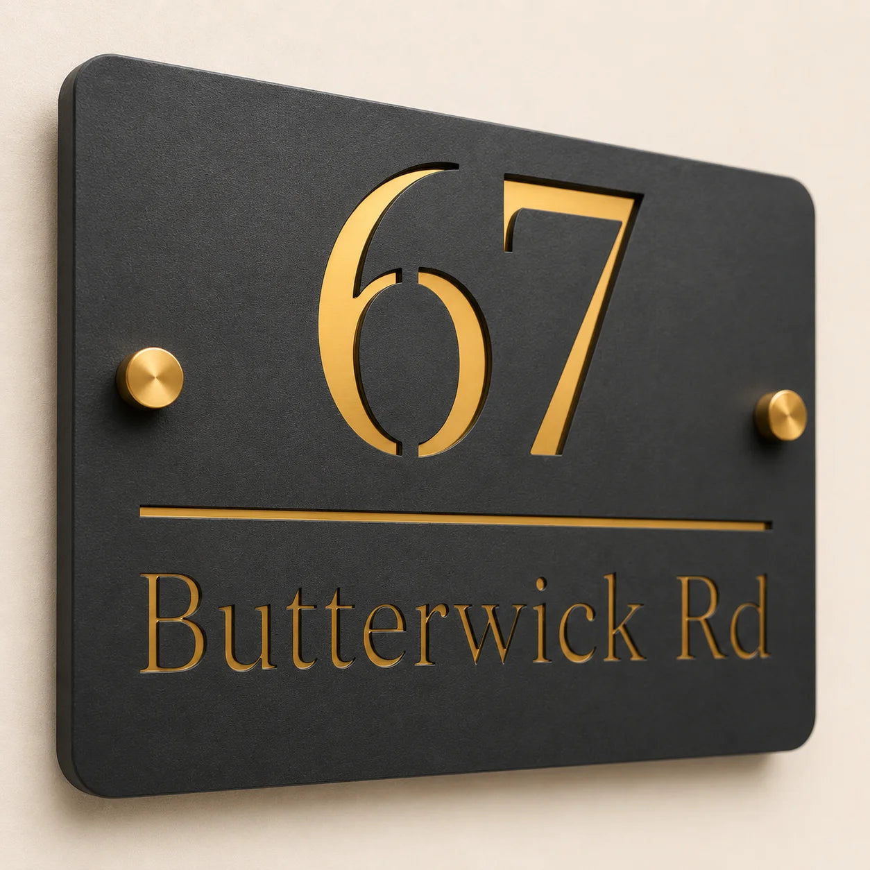 Close-up angled view of a personalised mineral grey acrylic house sign with raised gold mirror number 67, engraved address and brass stand-off fixings.