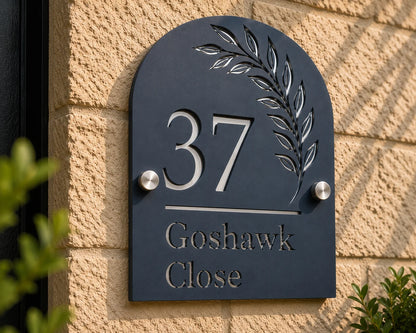 Close-up of personalised denim blue arch acrylic house sign with leaf design mounted on an exterior wall