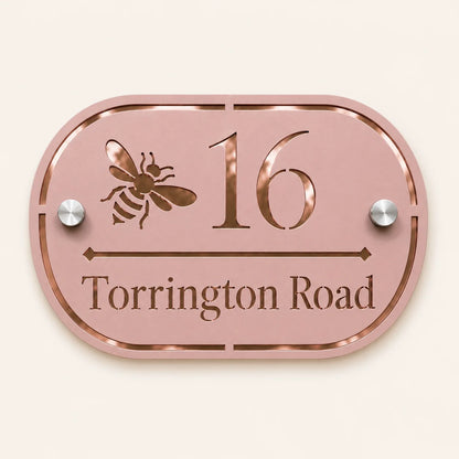 Personalised dusky pink oval acrylic house sign with mirror rose gold bee design, house number and street name