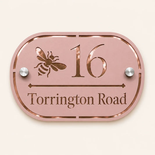 Personalised dusky pink oval acrylic house sign with mirror rose gold bee design, house number and street name