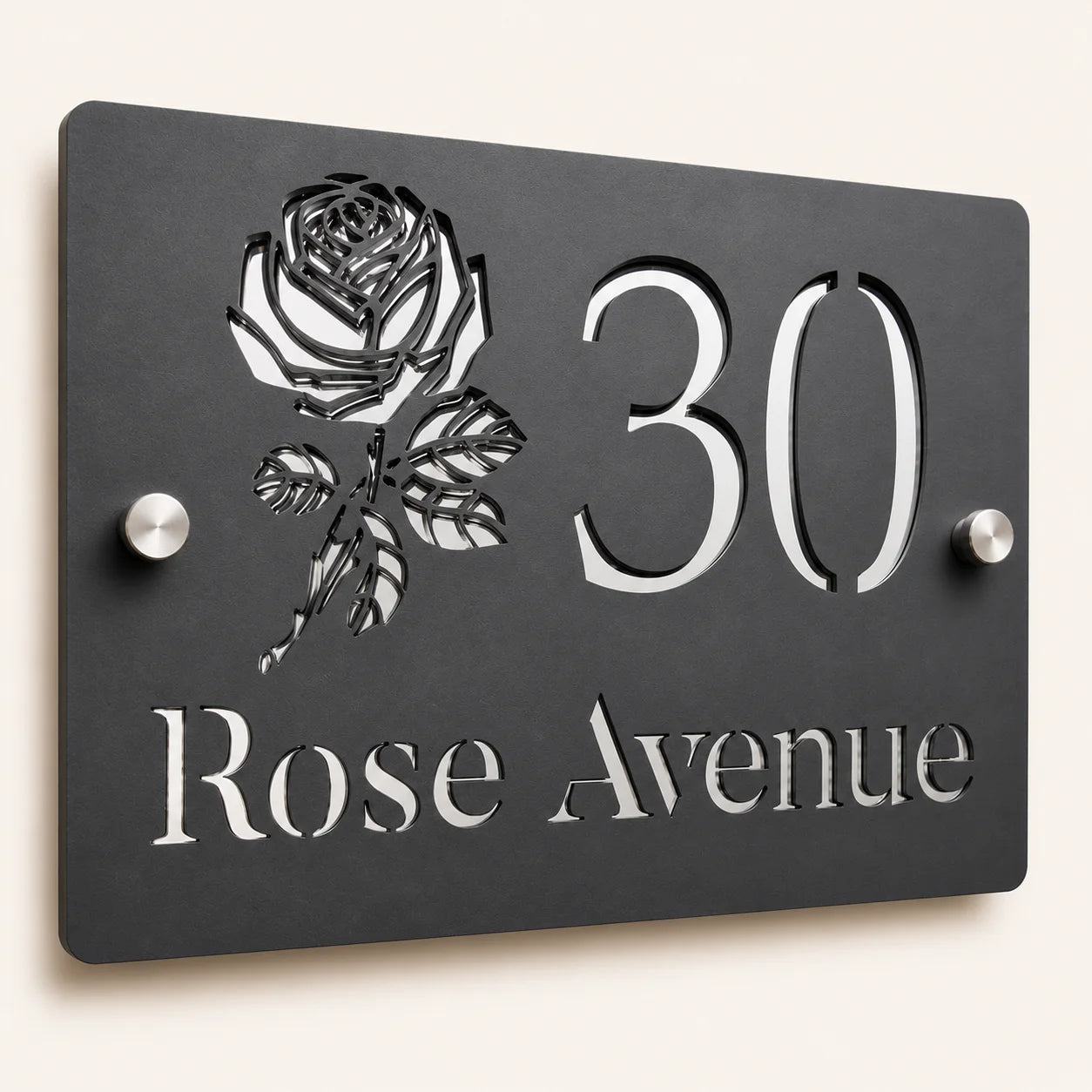 Close-up angled view of personalised mineral grey rectangular acrylic house sign with mirror silver rose design and lettering