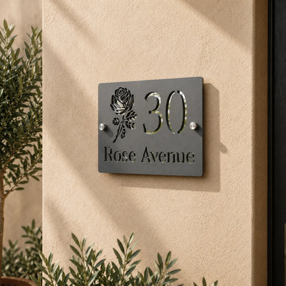 Close-up of personalised mineral grey rectangular acrylic house sign with mirror silver detailing mounted on an exterior wall