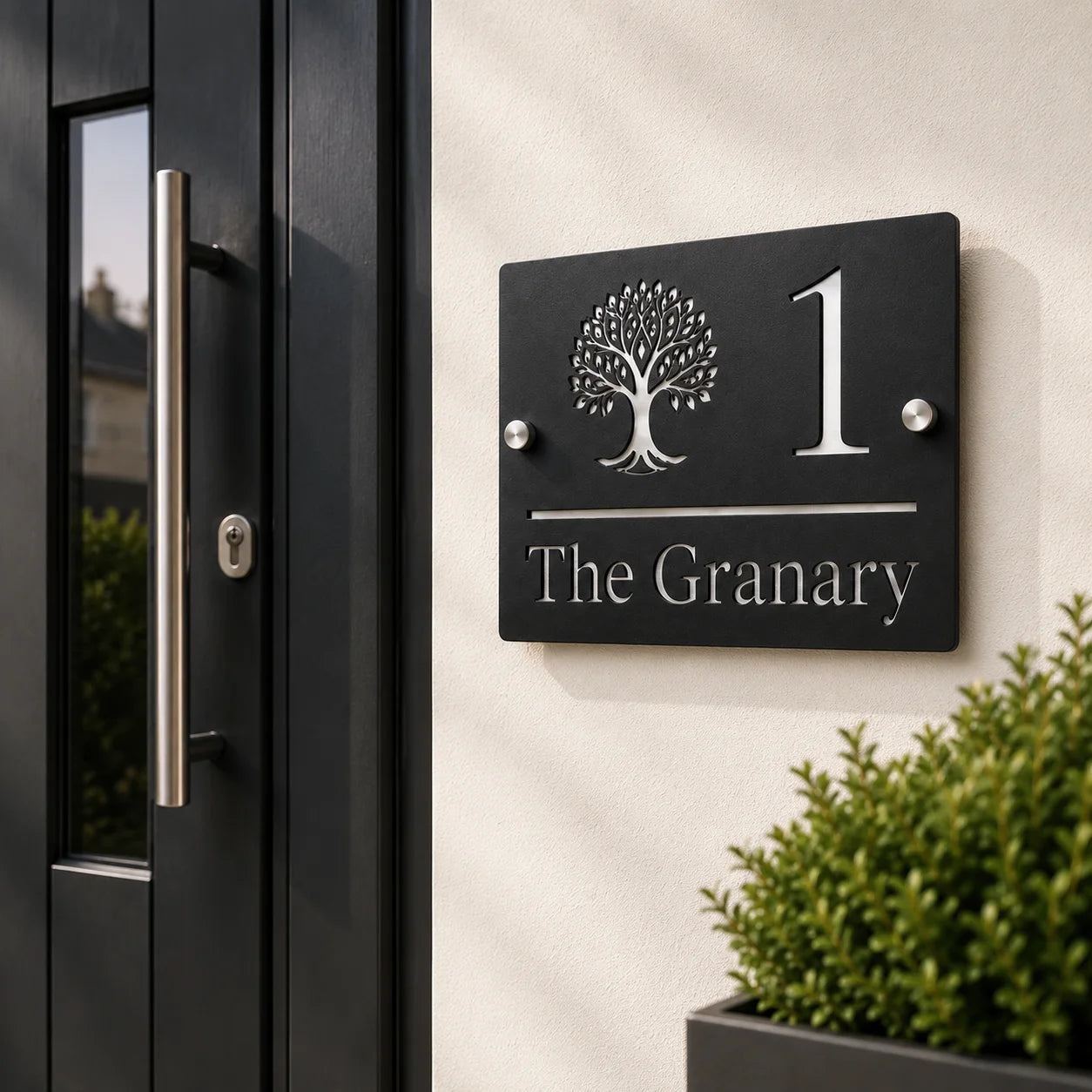 Personalised black rectangular acrylic house sign with mirror silver tree design mounted beside a modern front door