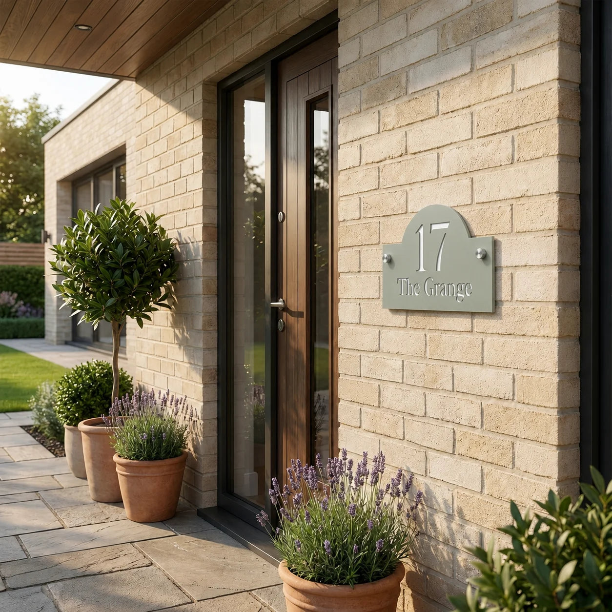 Personalised sage green arch acrylic house sign mounted beside a modern front door on a brick wall