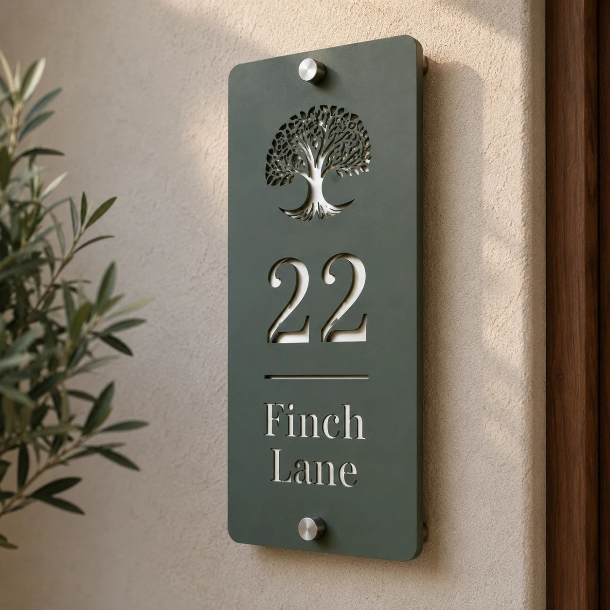 Close-up of personalised pine green and mirror silver acrylic house sign mounted beside a front door