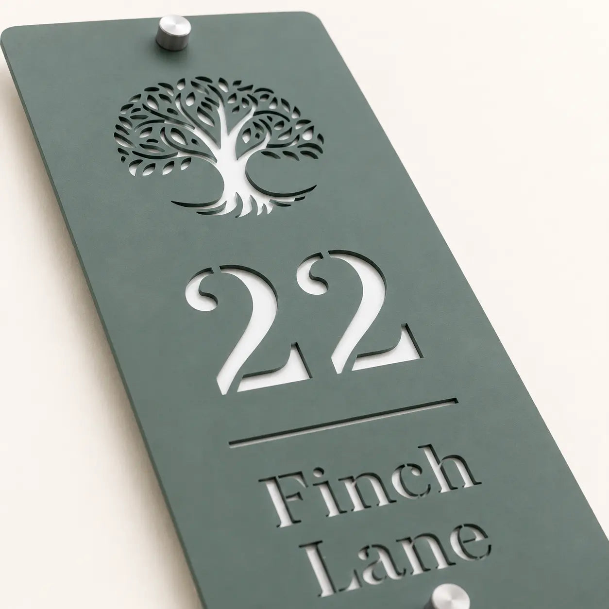 Close-up of personalised sage green house sign showing tree design and cut-out lettering