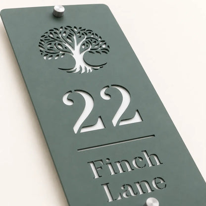 Close-up of personalised sage green house sign showing tree design and cut-out lettering