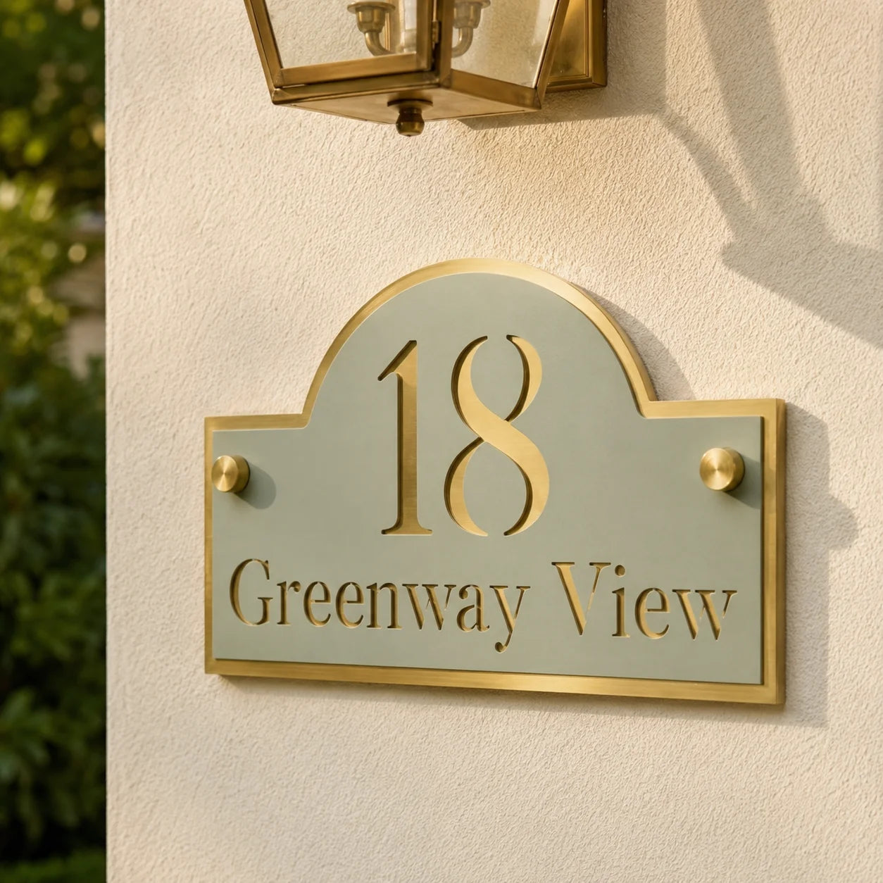 Close-up of personalised sage green and mirror gold acrylic house sign mounted on an exterior wall