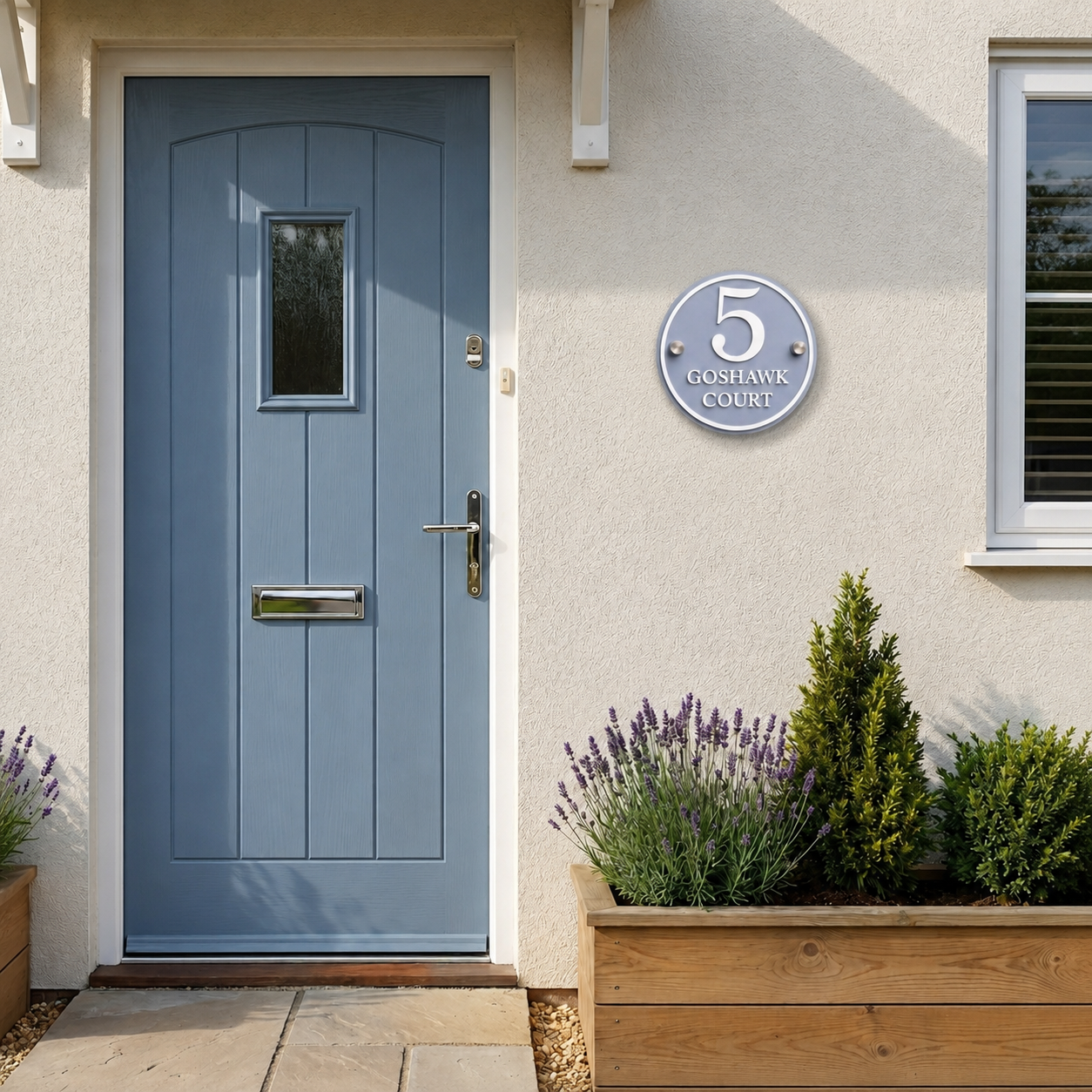 Dusky blue acrylic house sign with matt white lettering mounted beside a front door